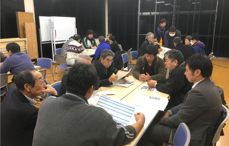 地域住民が5〜8人でグループを作り、複数のテーブルで話し合っている様子