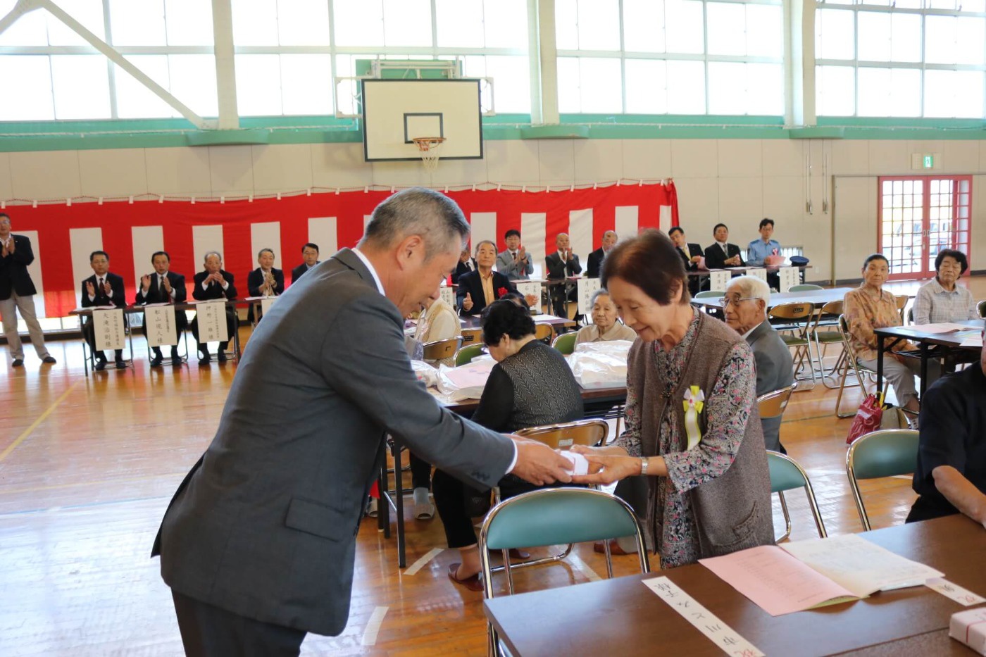川西町と地区社協推進委員会からの記念品が贈呈されている様子