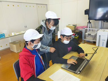 写真：小学生がパソコンを使って調べ物をしている