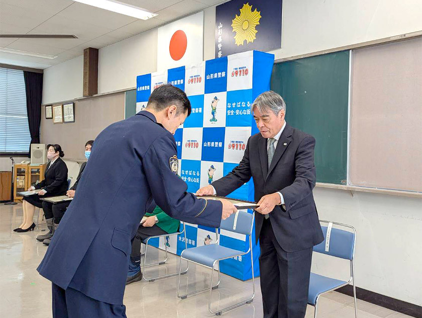 写真：「よしじまっ子見守り隊」（隊長　笹木喜一さん）が交米沢警察署長感謝状をいただいている様子